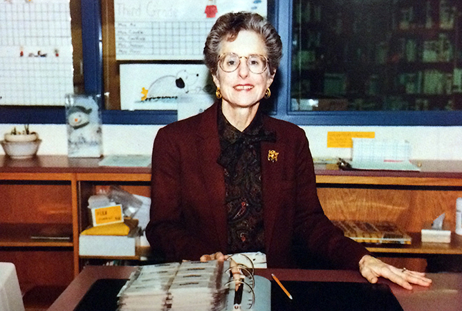 Yearbook photograph of librarian Linda Lellinger sitting at her desk.
